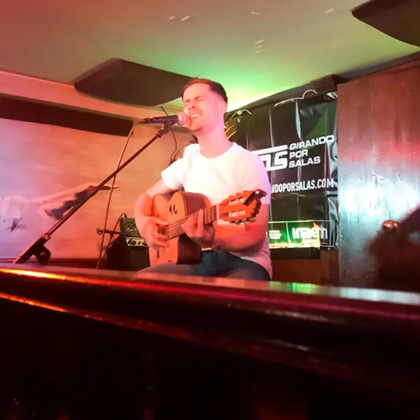 Cantante con guitarra en concierto en Avalon Café Zamora.