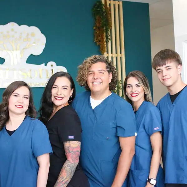 Equipo de profesionales de Adansonia Centro Estético, posando frente al logo del centro en Rivas-Vaciamadrid.